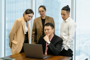 Group of professionals engaging in team collaboration at the office with a laptop.